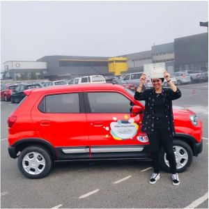 person in front of red car